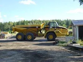 Gul dumper parkerad på en grusplan